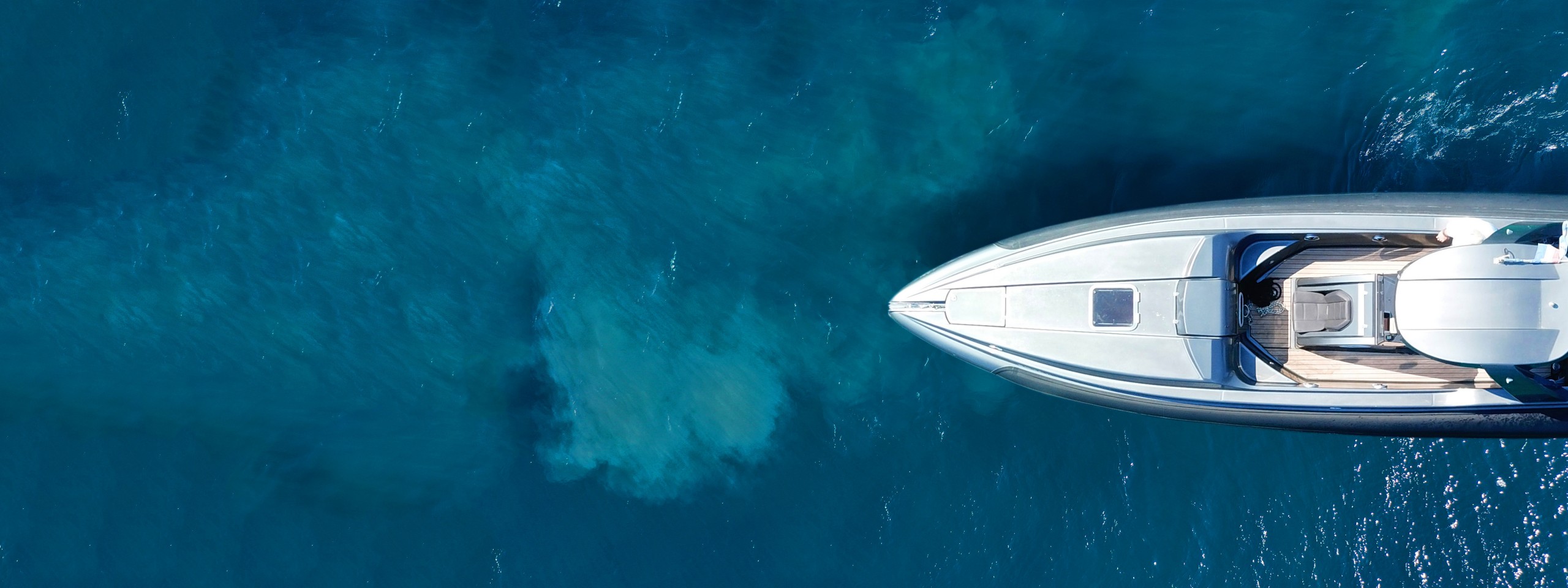 Aerial drone ultra wide top down photo of luxury rigid inflatable speed boat cruising in high speed in Aegean deep blue sea, Greece